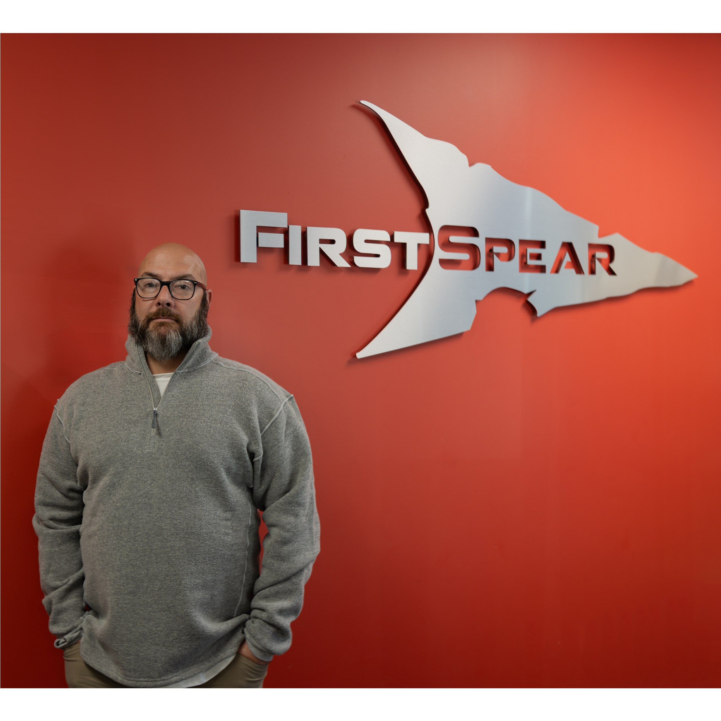 Brian Erb Stands in Front of FirstSpear Logo